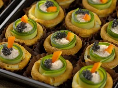 Канапе с крабовым мясом, слайсом из свежего огурчика и чёрной икрой палтуса